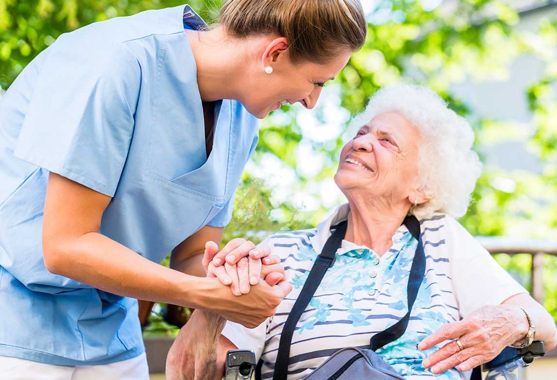A medical assistant assists an elderly patient.