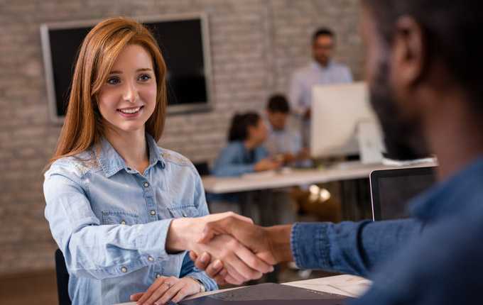 A woman and a man shake hands.
