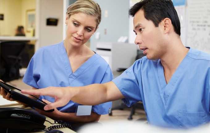 Two medical professionals review information.